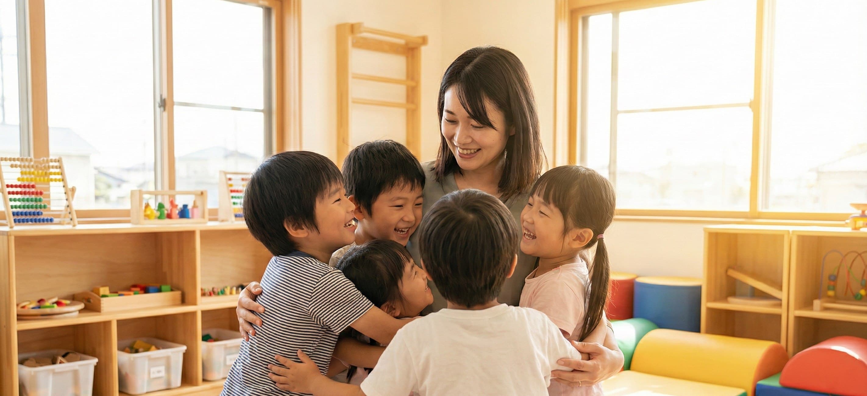 保育者と子どもたちが笑顔で触れ合う様子